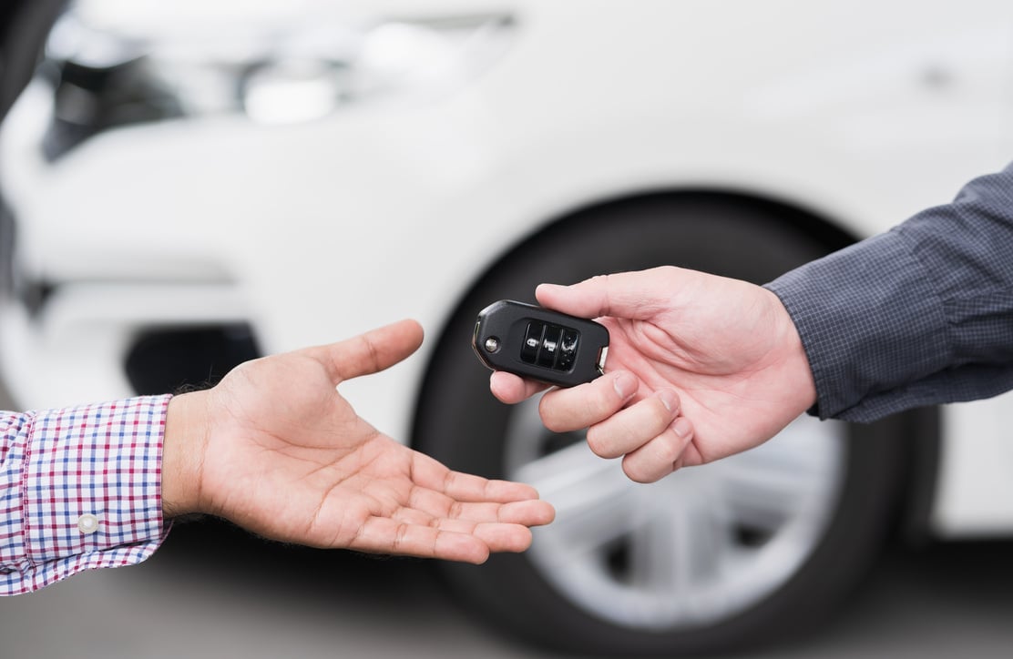 Young man buy the new car. Businessman giving a car key. Salesman car dealing success with customer.